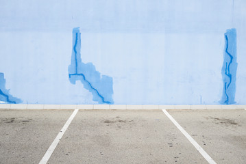 Urban blue wall with fissures.