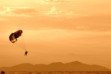 Parasailing in the evening sky near the coast of Vietnam. Orange color toned