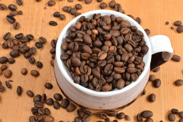 Coffee beans in a cup on a wooden board