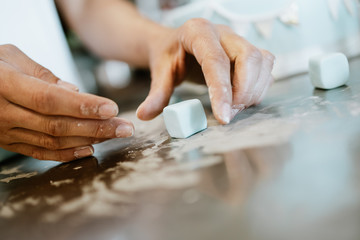 Professional confectioner working making and decorating delicious sweets. Close up shot.