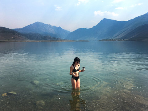 Woman in Bikini with Beer Standing in Mountain Lake