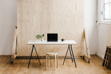 modern workspace with plywood backdrop wall in natural light studio