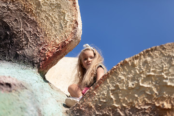 Emotional portrait of a positive and cheerful little girl with long hair, walk in the park. Happy childhood. Summertime. Summer vacation in nature