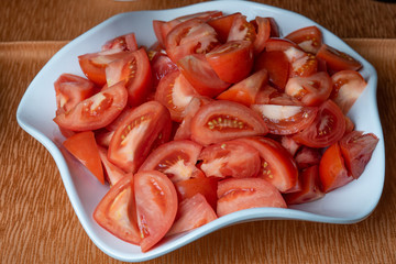 Fresh tomatoes cut into pieces in a plate
