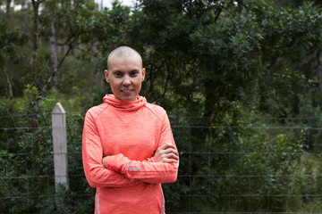 Confident hairless woman folded arms forest.