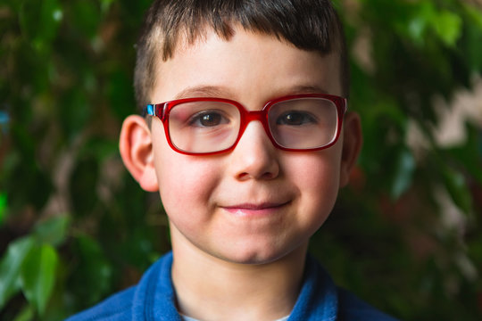 Male Child with Glasses Smiling at Camera