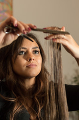 Naklejka premium hairdresser cuts a woman's hair