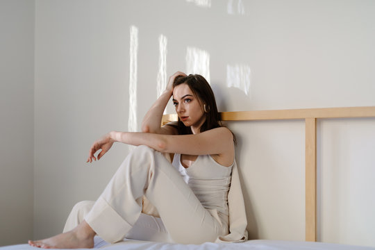 Sensual female sitting on bed