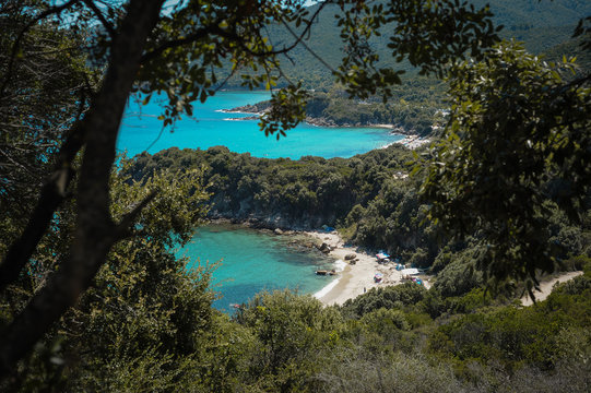 View of the boat and the sea through the forest. Blue sea and motorboat. The Sea Bay at the historic Greek city of Stagira