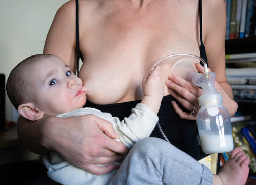 Mother Pumps Milk While Breastfeeding Her Baby
