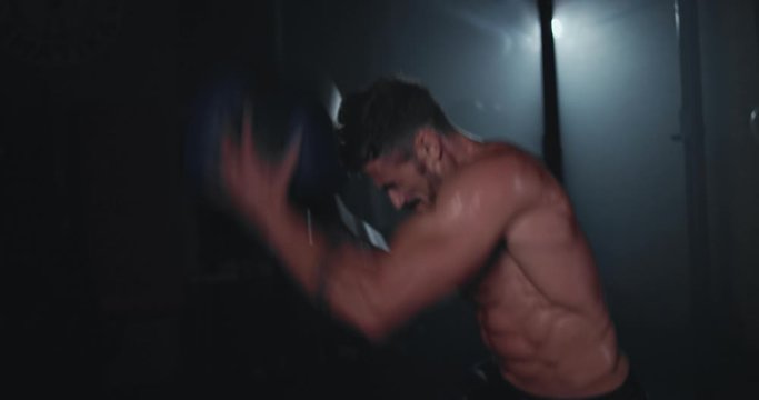 In front of the camera a hard workout training at cross fitness class guy with a ball working intense get sweating and concentrated to make more muscle on the abs