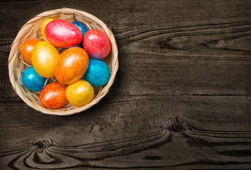 Obraz na płótnie Canvas Colored Easter eggs in a basket on a white background.
