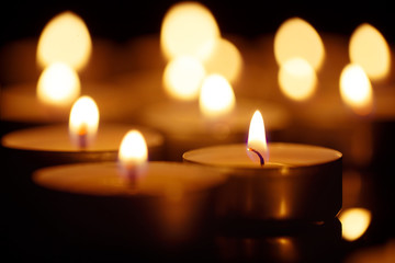 Burning candles on black background, shot with shallow depth of field