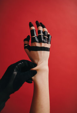 Crop hands in paint on red background