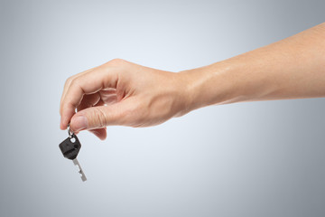 Hand with a key on gray background