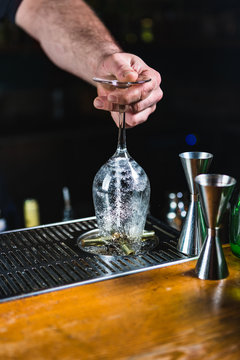 Unrecognizable Bartender Cleaning Glasses with Splashing Water