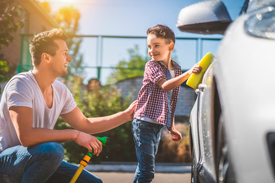 The father and his little son cleaning the car - Powered by Adobe