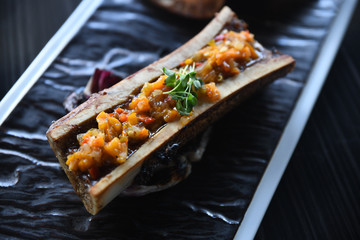 Close up of grilled vegetables and bone marrow on plate