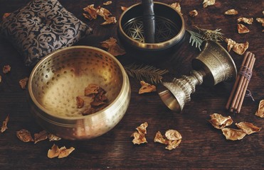 Tibetan themed close up with examples of two different singing bowls - a dark brown, and gold...