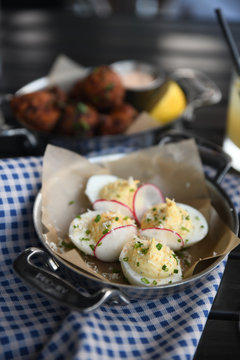 Deviled eggs with radishes served in wok