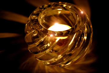 Votive candle burning in a cut glass holder