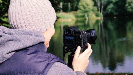 Girl photographer. The tripod with the camera.