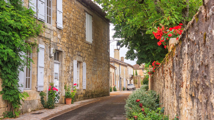 Fototapeta na wymiar Summer city landscape - view of a medieval street in a provincial French town, in the historical province Gascony, the region of Occitanie of southwestern France