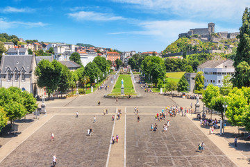 Summer city landscape - view of the square in front the Sanctuary of Our Lady in the town Lourdes,...