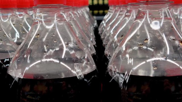 A lot of plastic bottles with cola in the store.