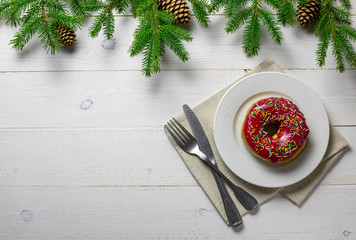 Fototapeta na wymiar Christmas or New Year background with fir tree, plate, cutlery, donut on white board