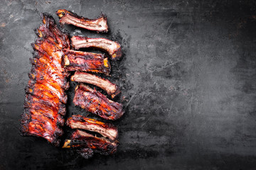 Barbecue pork spare ribs St Louis cut sliced with hot honey chili marinade as top view on an old rustic metal board with copy space right - obrazy, fototapety, plakaty
