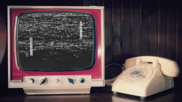 Analog scene (rotary phone, vintage TV): a badly distorted VHS tape with a recording of a simple video-game of two paddles hitting a ball (mock-up created from scratch).