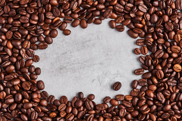 Coffee beans isolated on a grey concrete background. Coffee frame. Top view. Copy space. Design element.