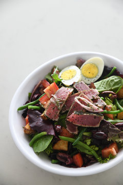 Close up of seared tuna over vegetable salad