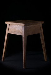 Handmade stool oak wood on a black background