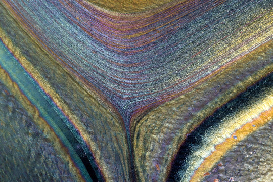 Closeup of patterns, colors and textures in a hand-made glass vase.