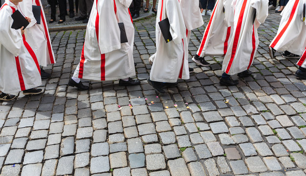 Altar Boys In Uniform Walking On A Cobbled Street