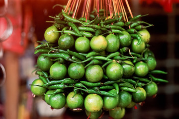 Lime and green chili peppers hanging outside an Indian store.