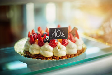 strawberry cake with cream with a price of ten euros in the shop window