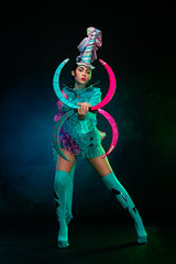 Two beautiful go-go dancer girls in freak costumes on disco party in color smoke. Night show women.