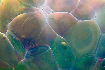 Closeup of the abstract colors, textures and patterns in the surface of a handmade glass globe (Christmas ornament)