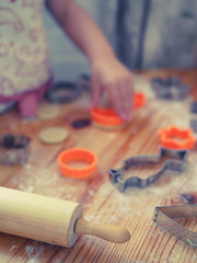 a child at home cuts out cookie cutters.