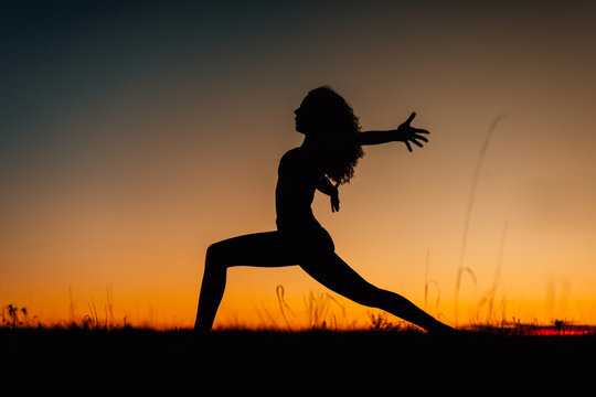 Silhouettes of people training yoga