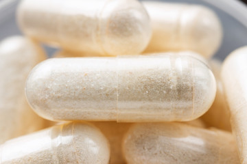 Fototapeta na wymiar White medical capsules of glucosamine chondroitin, healthy supplement pills, macro image
