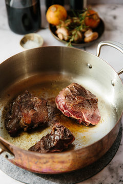 Cheap cuts of beef browning in a copper pan ready to be added to a stew.