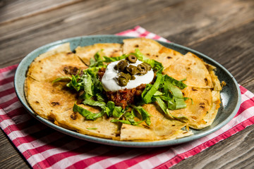 tortilla with tomato sauce, olives and sour cream