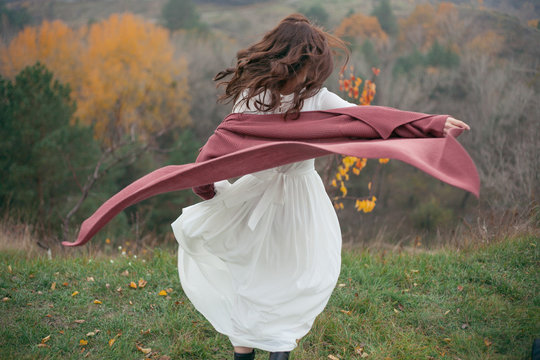 plaid and girl's hair fluttering in the wind against the backdrop of the autumn forest
