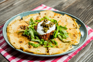 tortilla with tomato sauce, olives and sour cream