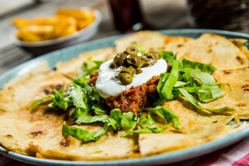 tortilla with tomato sauce, olives and sour cream