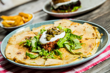 tortilla with tomato sauce, olives and sour cream